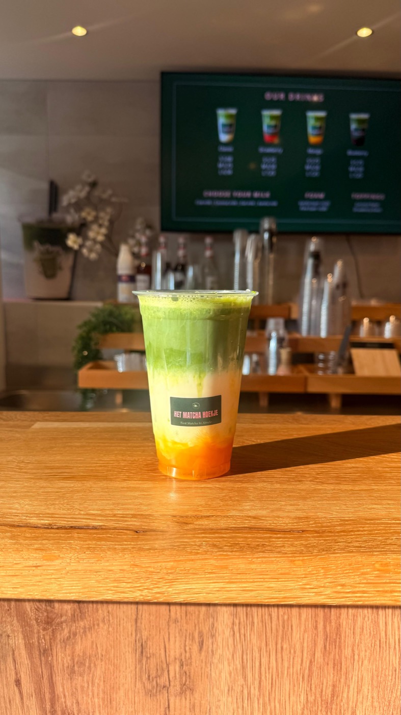 Mango matcha op de bar met het menubord op de achtergrond